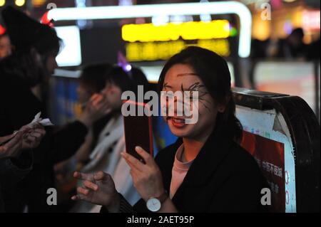 Une personne regarde son maquillage en utilisant son téléphone dans une rue de la ville de Shenyang, au nord-est de la Chine, la province de Liaoning, 31 octobre 2019. Banque D'Images