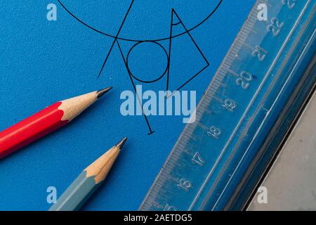 Plan de dessin sur une surface de couleur en utilisant le crayon, règle, compas et d'autres outils, des formes géométriques Banque D'Images