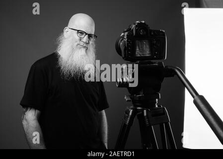 Homme chauve avec maturité longue barbe vlogging en noir et blanc Banque D'Images