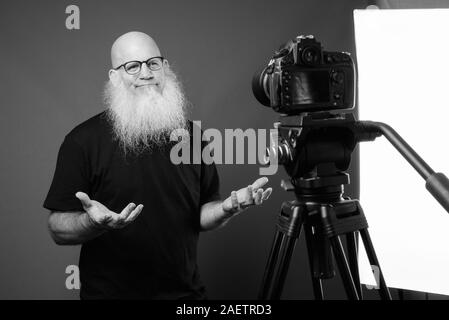 Homme chauve avec maturité longue barbe vlogging en noir et blanc Banque D'Images