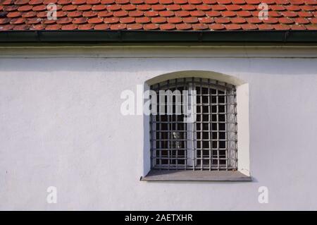 Historique ancienne façade blanc plâtrés et essuyé avec une fenêtre et une grille de fer en face de l'établissement red roof comme arrière-plan en Bavière Banque D'Images