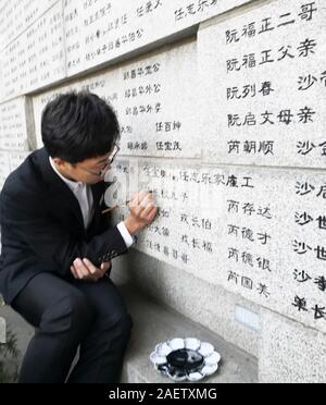 Les bénévoles d'universités locales retrouver les noms de victimes, qui ont été tués par les soldats japonais durant le massacre de Nanjing dans les Première Guerre mondiale Banque D'Images