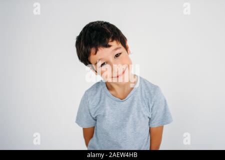 Cute smiling tween boy looking at camera sur le fond blanc Banque D'Images