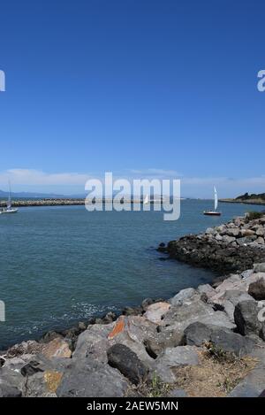 Des bateaux naviguant dans le Berkeley Marina de la baie de San Francisco. La péninsule de Marin County est visible dans le lointain. Banque D'Images