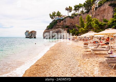 Baia delle Zagare, Gargano, Puglia, Italie - 10 septembre 2019 : Les gens se reposer sur des chaises longues, bains de soleil et nager dans la mer Adriatique. Célèbre stac mer Banque D'Images