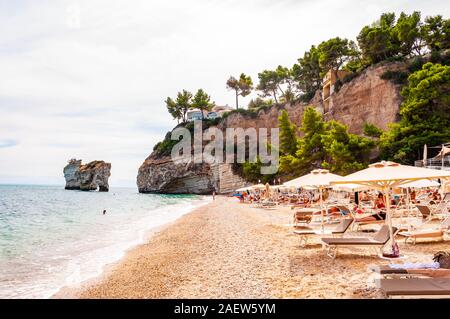 Baia delle Zagare, Gargano, Puglia, Italie - 10 septembre 2019 : Les gens se reposer sur des chaises longues, bains de soleil et nager dans la mer Adriatique. Célèbre stac mer Banque D'Images