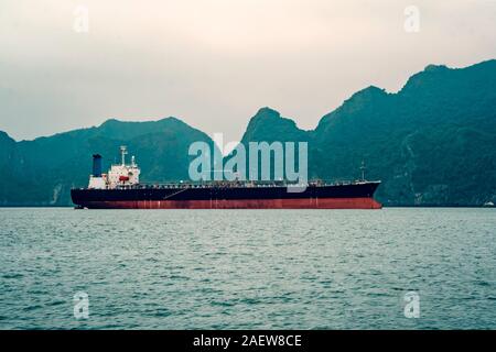 Gros tanker ancré dans la baie. Un grand navire de transport dans la mer dans le contexte de hautes roches. Vietnam, Ha Long Banque D'Images