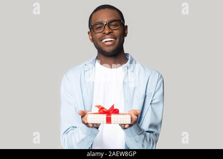 Joyeux Millénaire afro-américain guy holding present box head shot portrait. Banque D'Images