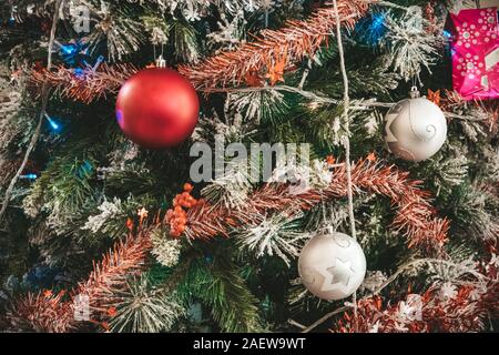 Arbre de Noël décoré libre. Boules rouge et argent et allumé garland avec lampes de poche. Nouvelle Année baubles macro photo avec effet bokeh. Hiver holid Banque D'Images