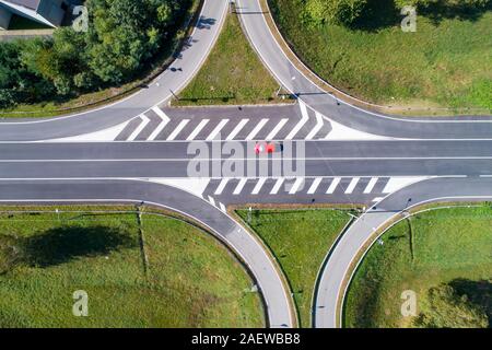 Traversée de la route et voiture rouge vu de dessus Banque D'Images