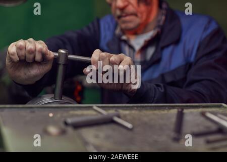 Close-up of senior man holding et levier de l'allumer tout en travaillant sur la machine Banque D'Images