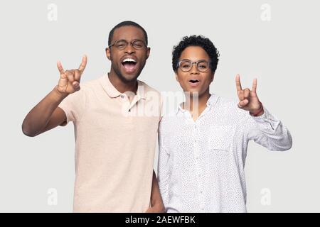 Heureux mixed race couple marié ethniques montrant rock-n-roll geste. Banque D'Images