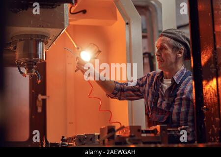 Man travailler comme électricien il travail avec les fils sur la machine dans l'usine Banque D'Images
