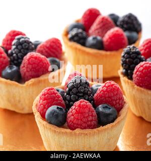 Gâteaux - tartelette Framboises, mûres et bleuets fond blanc Banque D'Images