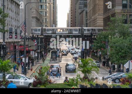 Chicago, Illinois, USA - Circa 2019 : Vue vers le bas rue animée dans le centre-ville en train passe en boucle sur les voies aériennes matin avenue l'heure de pointe et de la foule Banque D'Images