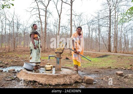 AMRAVATI, Maharashtra, Inde, 11 juin 2017 : les femmes rurales indiennes non identifié à transporter l'eau sur leurs têtes dans des pots traditionnels à partir de la pompe à main, tous les jours W Banque D'Images