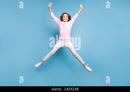 La taille du corps sur toute la longueur de la photo dentelée positif fille transmission étend ses bras et jambes en forme de saut d'étoile rose bleu pastel isolés Banque D'Images