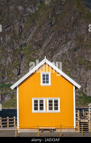 Une pêche jaune cabines dans Sakrisoy, un petit village de pêche dans les îles Lofoten Moskenes Municipalité le comté de Nordland en Norvège, avec une montagne je Banque D'Images