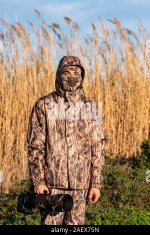 Photographe naturaliste en action, de camouflage et de la caméra, dans le désert. Banque D'Images