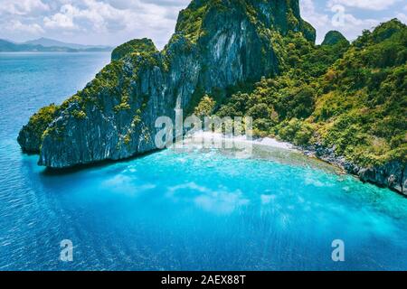 El Nido, Palawan. Drone aérien vue de l'île tropicale Entalula. D'immenses falaises de roches abruptes montagnes avec Blue Bay et de beaux récifs coralliens intacts Banque D'Images