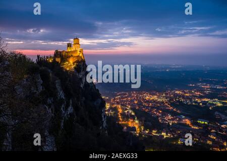 Vue de la forteresse Guaita lumineux sur le mont Titano, paysage de montagne au loin, dans la nuit Banque D'Images