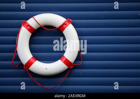 Anneau de sauvetage maritime comme un symbole de salut et d'espoir se bloque sur un mur bleu, également en tant que modèle Banque D'Images