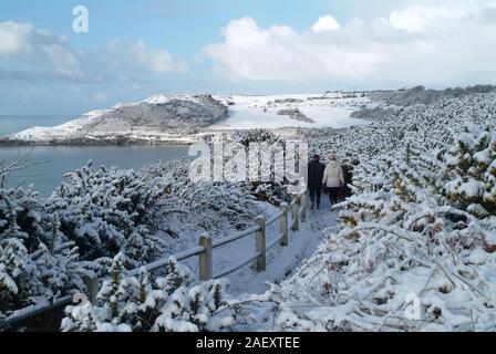 Scène de neige - Baie de Langland, Pays de Galles UK avec des promeneurs - a winter wonderland par la mer. Banque D'Images