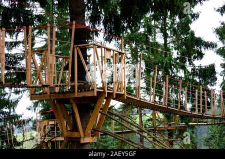 Piliers en bois et cordes suspendues d'un parc sur l'arrière-plan de forêt verte dans les Carpates Banque D'Images
