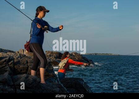 Deux jeunes femmes pour la pêche à la mouche sur le bar d'un après-midi d'été dans le Maine. Banque D'Images