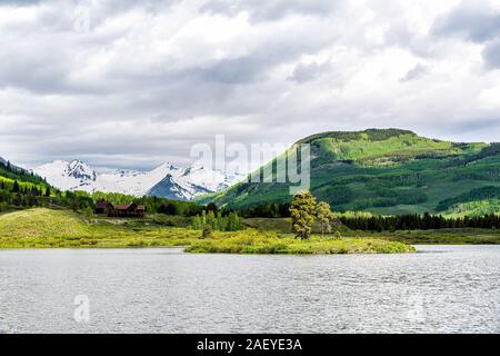 Crested Butte, Colorado lac d'arachide sur chemin de randonnée pédestre en été par jour nuageux avec de l'herbe verte prairie, vue sur la montagne et de l'eau Banque D'Images