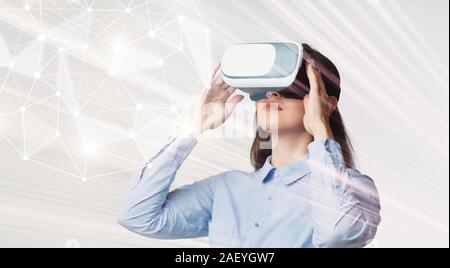 Jeune femme d'affaires à lunettes VR à la 3D au modèle interactif, en réalité différente, les technologies modernes, panorama concept Banque D'Images