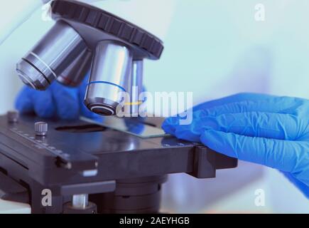 Close up of woman part portant sur des échantillons de verre sous microscope lentilles , copy space Banque D'Images