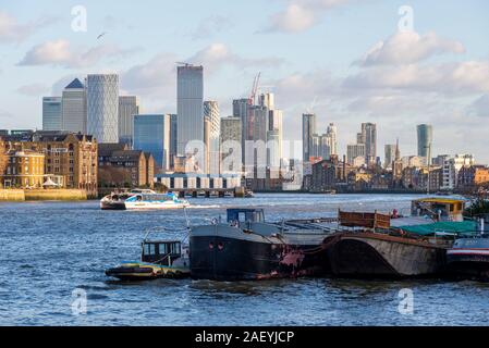 Bateaux et péniches amarrés à Tower Bridge Moorings, Downings Roads avec des tours de Canary Wharf secteur bancaire, quartier financier au-delà. Tamise Banque D'Images