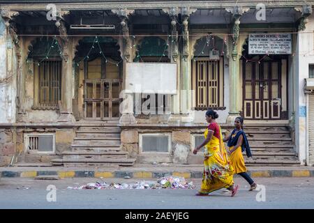 Deux femmes en vêtements colorés marchent devant une vieille maison dans les rues de la vieille ville. Banque D'Images