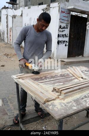 L'homme fait palestinien des chaises de bois, en raison de leur incapacité à acheter de nouveaux bois en raison de la détérioration économique, dans la bande de Gaza. Banque D'Images