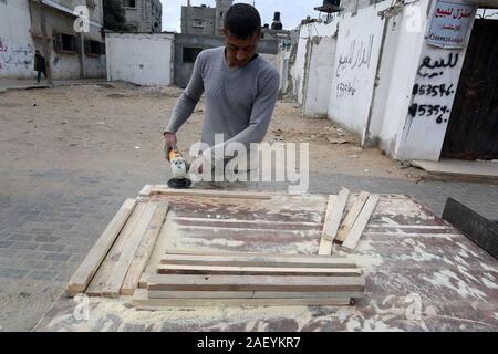 L'homme fait palestinien des chaises de bois, en raison de leur incapacité à acheter de nouveaux bois en raison de la détérioration économique, dans la bande de Gaza. Banque D'Images