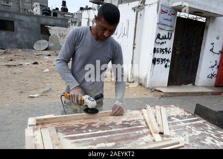 L'homme fait palestinien des chaises de bois, en raison de leur incapacité à acheter de nouveaux bois en raison de la détérioration économique, dans la bande de Gaza. Banque D'Images