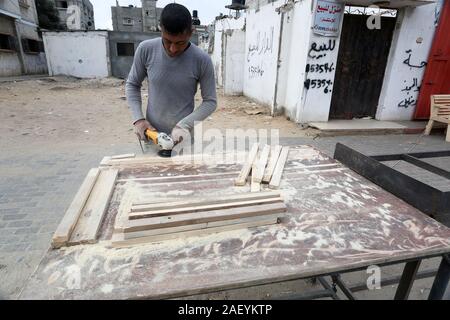 L'homme fait palestinien des chaises de bois, en raison de leur incapacité à acheter de nouveaux bois en raison de la détérioration économique, dans la bande de Gaza. Banque D'Images