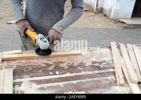 L'homme fait palestinien des chaises de bois, en raison de leur incapacité à acheter de nouveaux bois en raison de la détérioration économique, dans la bande de Gaza. Banque D'Images