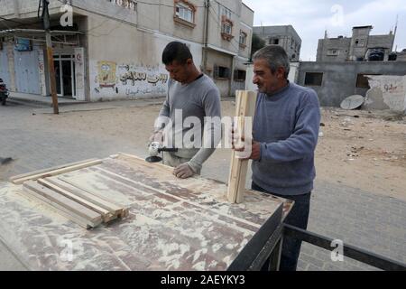 L'homme fait palestinien des chaises de bois, en raison de leur incapacité à acheter de nouveaux bois en raison de la détérioration économique, dans la bande de Gaza. Banque D'Images