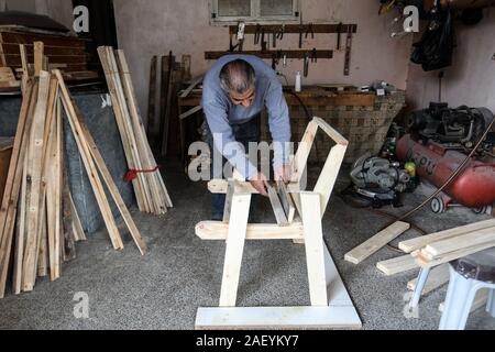 L'homme fait palestinien des chaises de bois, en raison de leur incapacité à acheter de nouveaux bois en raison de la détérioration économique, dans la bande de Gaza. Banque D'Images