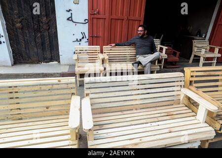 L'homme fait palestinien des chaises de bois, en raison de leur incapacité à acheter de nouveaux bois en raison de la détérioration économique, dans la bande de Gaza. Banque D'Images