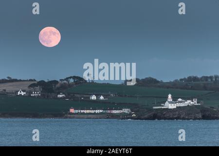 Authier, en Irlande. 11 Décembre, 2019.. Une pleine lune froide augmente à mesure que les derniers rayons de soleil d'hiver illumine les Roches Point Phare du Port de Cork, Irlande. - Crédit ; David Creedon / Alamy Live News Banque D'Images