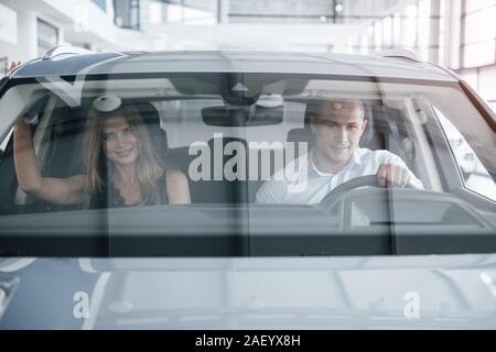Vue de face. Gestionnaire positif montrant les caractéristiques de la nouvelle voiture pour la clientèle féminine Banque D'Images
