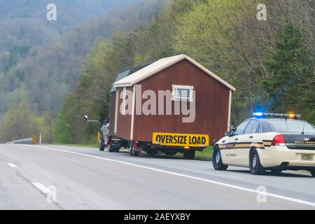 Erwin, USA - Le 19 avril 2018 : Smoky Mountains du Tennessee hills road sign et l'arrêt du véhicule de police charge surdimensionnée dépanneuse petite maison Banque D'Images