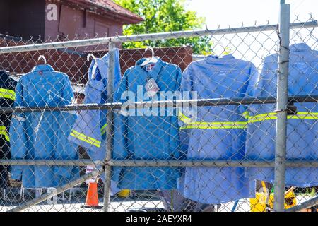 Atlanta, États-Unis - 20 Avril 2018 : l'extérieur du complexe industriel au centre-ville de New York City avec l'uniforme bleu vestes travailleurs suspendus sur fence Banque D'Images