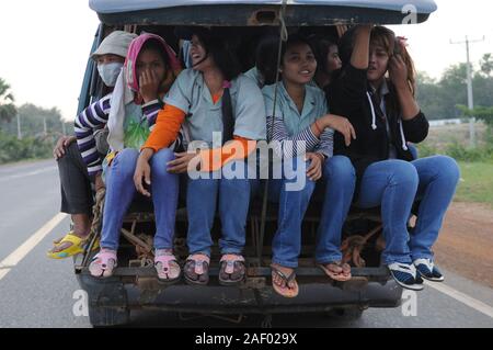 Femmes cambodgiennes, vêtements, empaillés à l'arrière d'une fourgonnette portant des jeans et des tongs bleu denim. Province de Kampong Speu, Cambodge. © Kraig Lieb Banque D'Images