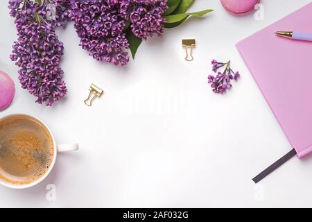 La composition créative avec des accessoires féminins, belles fleurs lilas, café et macarons, vue du dessus Banque D'Images