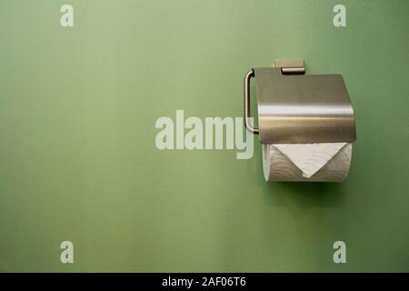 Close-up de papier pour WC dans salle de bains près de muraille verte Banque D'Images