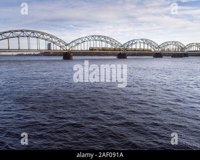 Un train traverse la rivière Daugav la position à la Gare Centrale de Riga par une froide journée de mars 2018 Banque D'Images